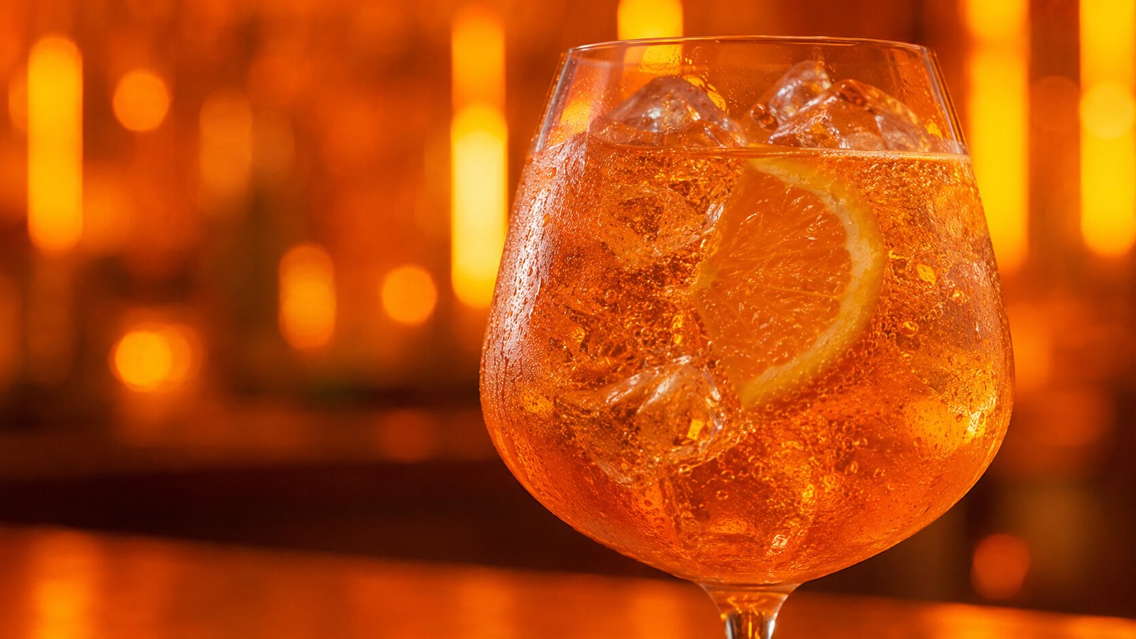 Alkoholfreier Aperol Spritz im Neonlicht Alkoholfreier Aperol Spritz im Glas vor farbigem Neonlicht