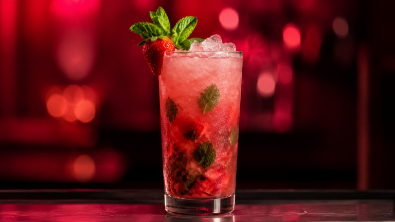 Erdbeer Mojito vor extrem unscharfem Neonhintergrund in der Farbe des Drinks