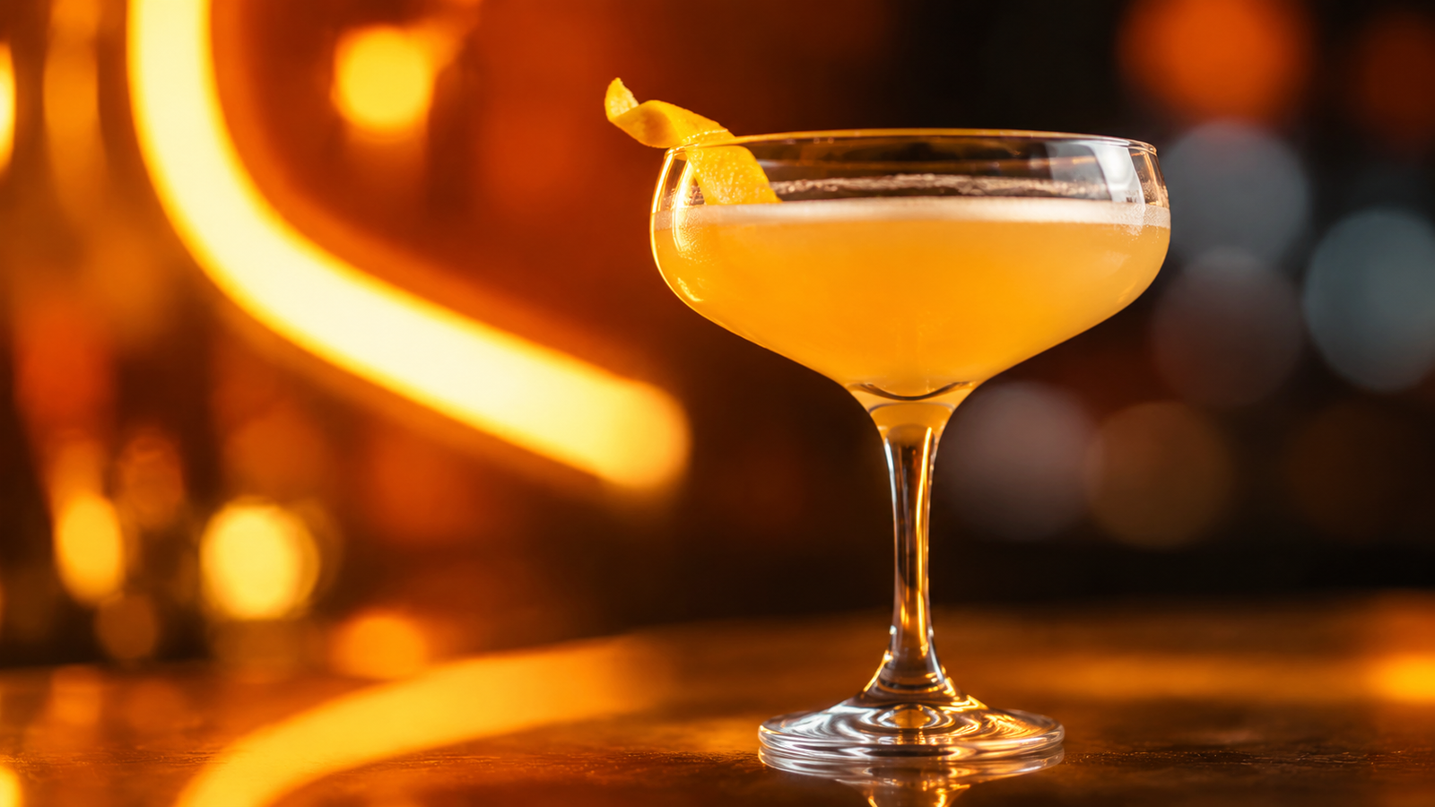 Sidecar vor extrem unscharfem Neonhintergrund in der Farbe des Drinks